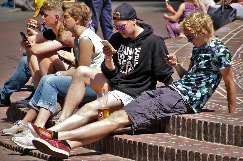 Jugendliche im Freien die in ihr Handy schauen