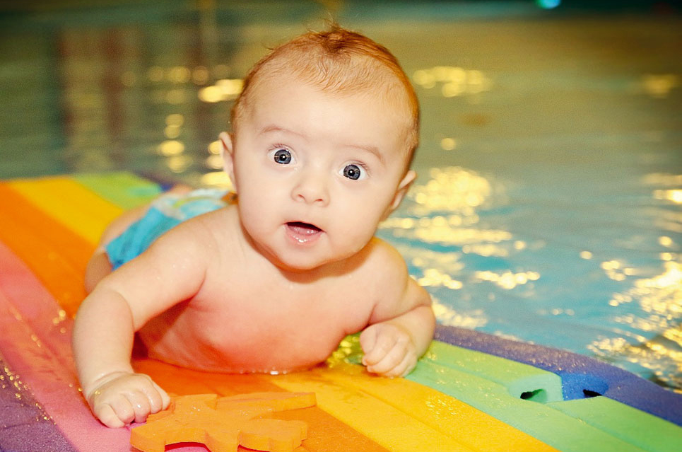 Baby auf einer Schwimmmatte im Wasser