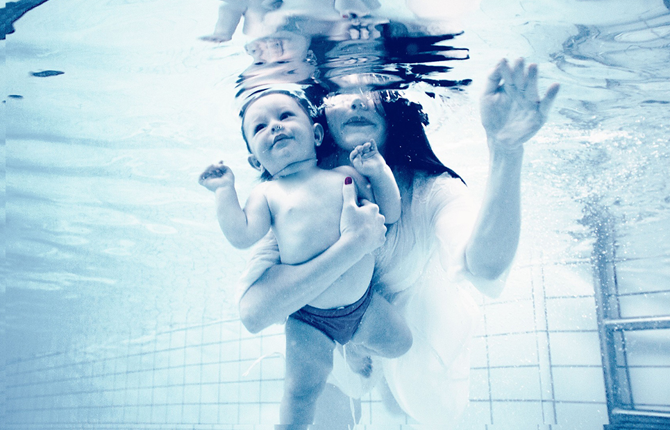 Mama mit Baby unter Wasser in einem Schwimmbecken