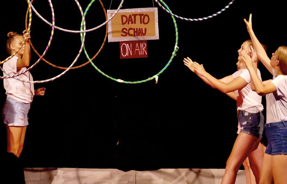 Mädchen die in einer Zirkusvorstellung mit Reifen jonglieren