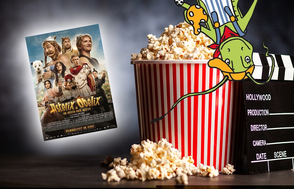 Ein voller Popcorneimer auf einem dunklen Hintergrund, mit Filmplakat von "Asterix und Obelix im Reich der Mitte"